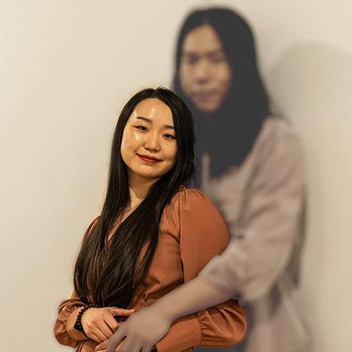 A young man with long hair and a woman. The woman is out of focus. When you move the cursor over the image, the woman comes into focus.