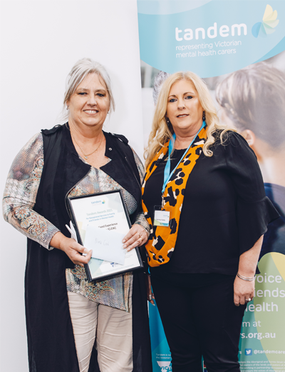 Nina Cook is presented the Carer Lived Experience Workforce (CLEW) Award by Tandem Board member, Katrina Clarke